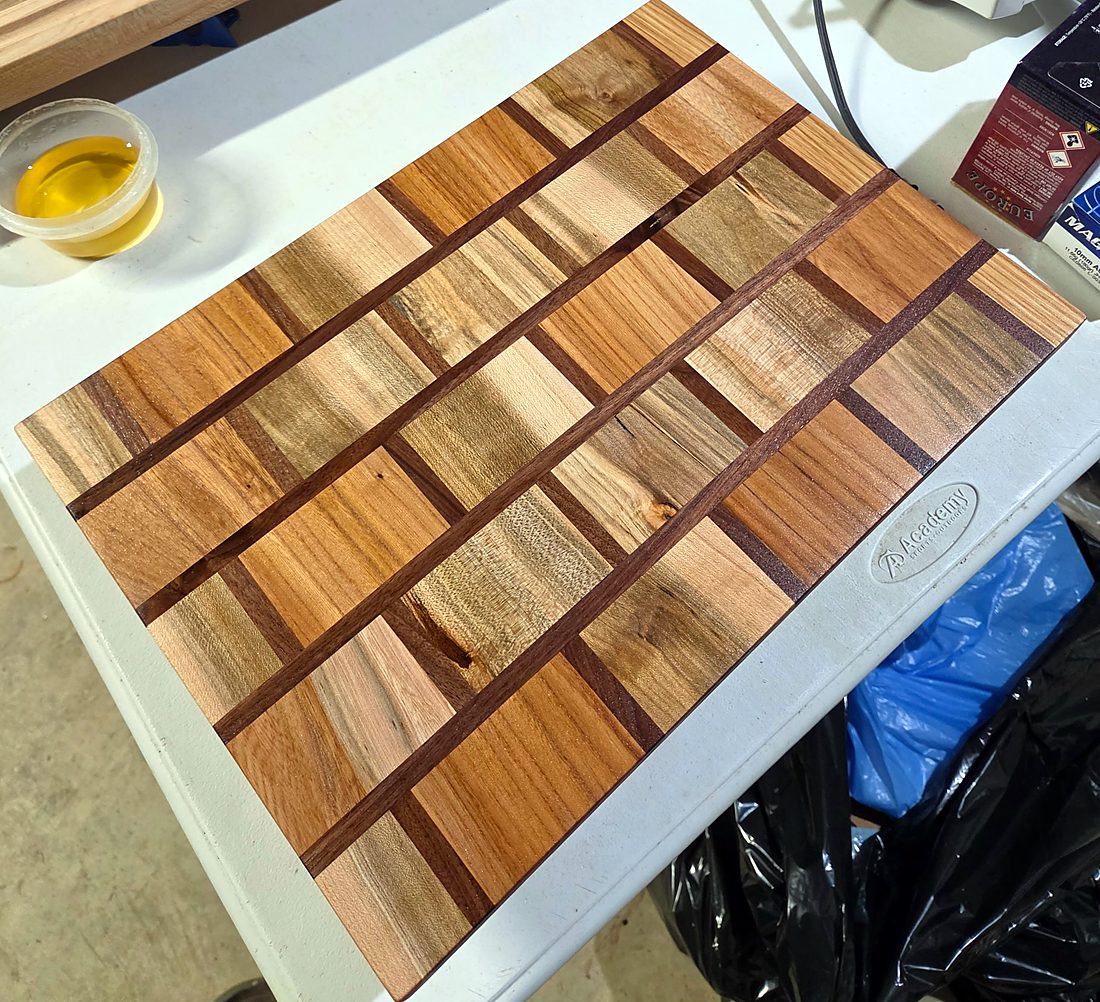 Cutting board of mixed hardwoods with walnut strips