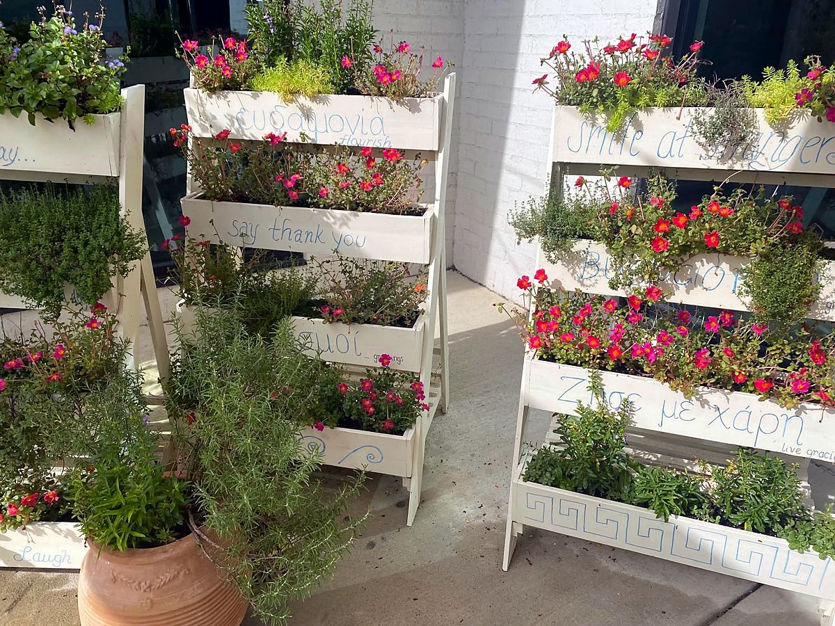 Painted tiered planters filled with flowers and herbs