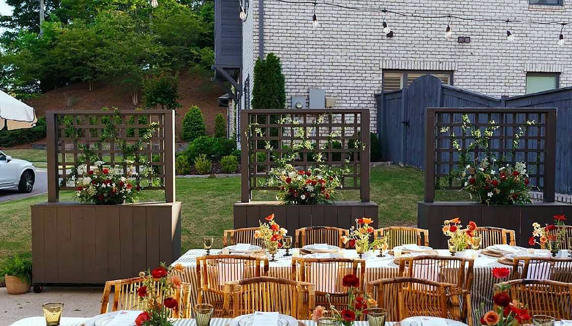 Finished rolling planters with trellis screens at an outdoor dinner
